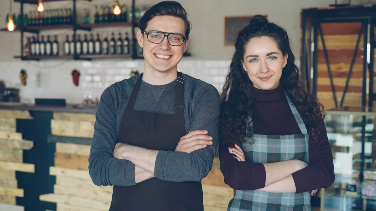 Two café owners in aprons behind their counter